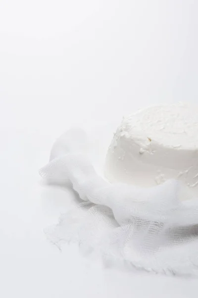 Close-up shot of creamy cottage cheese on cheesecloth on white surface — Stock Photo