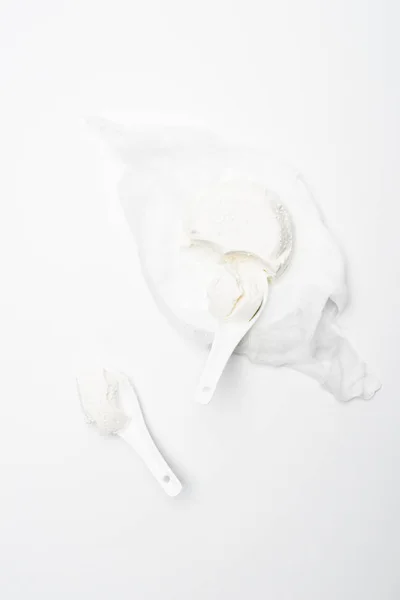 Vista dall'alto di fiocchi di latte fatti in casa con cucchiai sulla superficie bianca — Foto stock