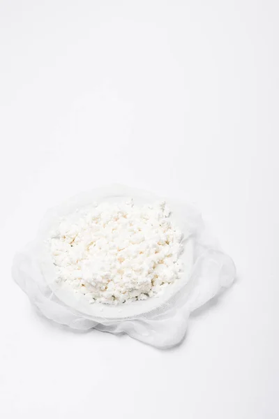 Homemade cottage cheese on cheesecloth on white surface — Stock Photo