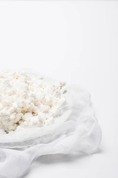 Close-up shot of cottage cheese on cheesecloth on white surface — Stock Photo