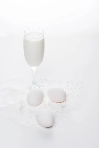 Hühnereier mit Mehl und Milch auf weißer Oberfläche — Stockfoto