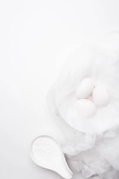 Vista superior de ovos de galinha na toalha de queijo com creme azedo na colher na superfície branca — Fotografia de Stock