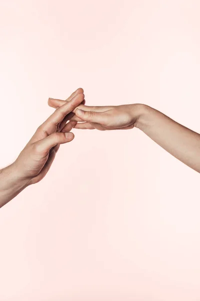 Обрезанный образ женщины и мужчины, соединяющих руки изолированы на розовом фоне — стоковое фото