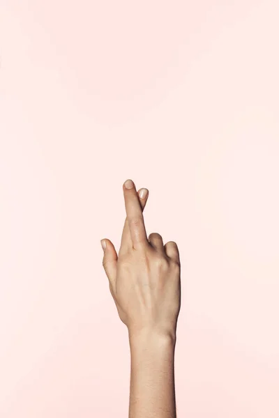 Partial view of woman doing crossed fingers gesture isolated on pink background — Stock Photo