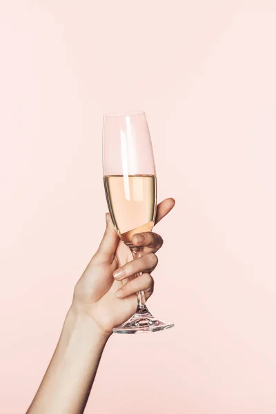 Cropped shot of woman cheering by champagne glass isolated on pink background — Stock Photo