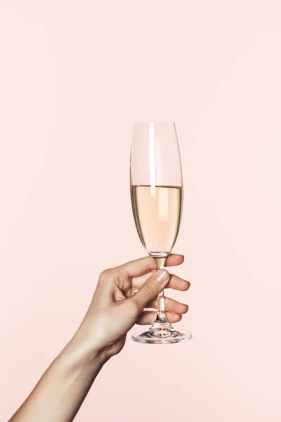 Vista parcial da mulher segurando copo de champanhe isolado no fundo rosa — Fotografia de Stock