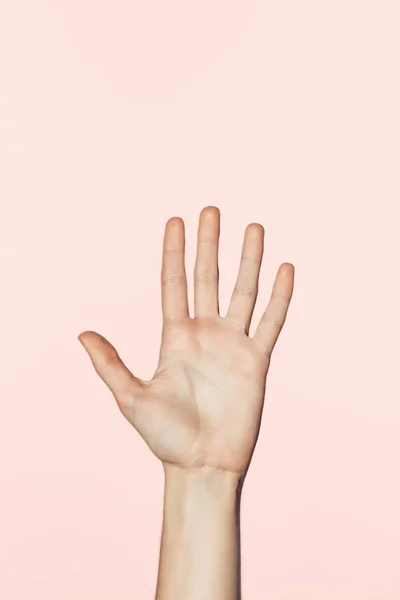 Частичный вид женской руки на розовом фоне — стоковое фото