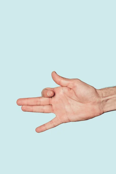 Partial view of man doing hand dog isolated on blue background — Stock Photo