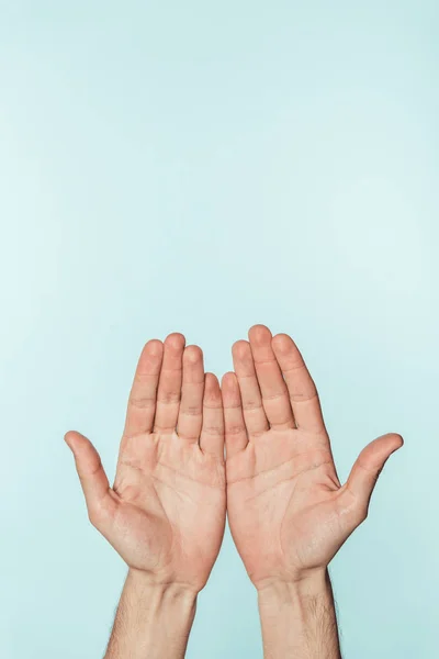 Immagine ritagliata dell'uomo che mostra palme aperte isolate su sfondo blu — Foto stock