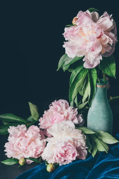 Bouquet floristique de pivoines rose clair dans un vase sur fond sombre — Photo de stock