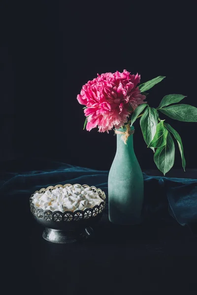 Flor de peônia em vaso e tigela vintage com marshmallows doces no fundo escuro — Fotografia de Stock