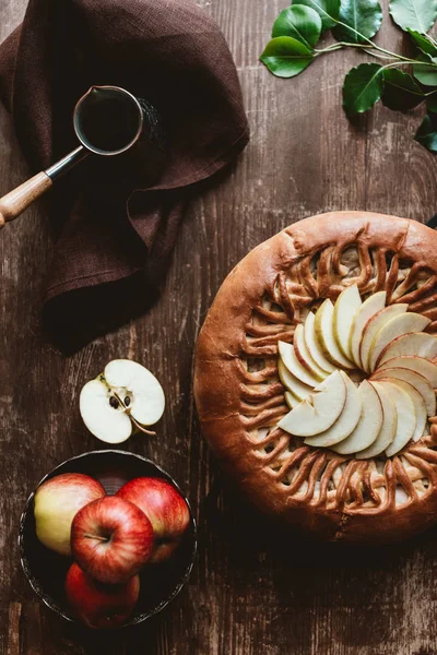 Flat lay com torta de maçã caseira, cafeteira e maçãs frescas na mesa de madeira — Fotografia de Stock