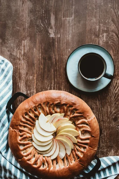 Top view of homemade apple pie and cup of coffee on wooden tabletop — Stock Photo