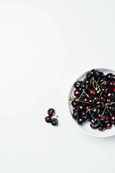 Vista superior de cerezas dulces maduras frescas en un tazón sobre fondo blanco - foto de stock