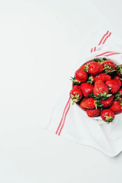 Tp vue de fraises douces rouges fraîches mûres dans un bol avec serviette sur blanc — Photo de stock