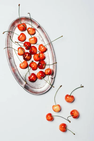 Vue de dessus de cerises douces mûres fraîches sur plaque vintage sur blanc — Photo de stock