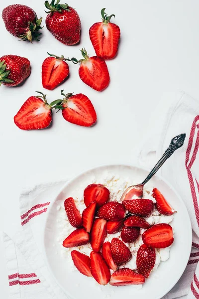 Vista superior de fresas en rodajas maduras y queso cottage saludable en blanco - foto de stock