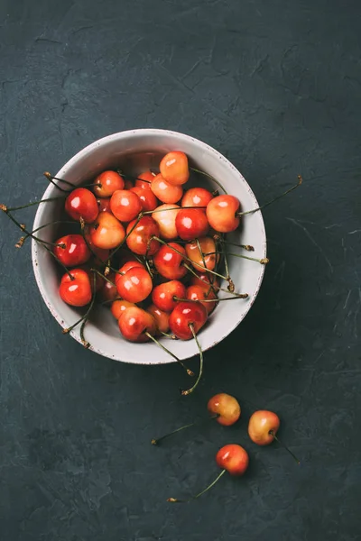Top view of fresh ripe sweet cherries in bowl on black — Stock Photo