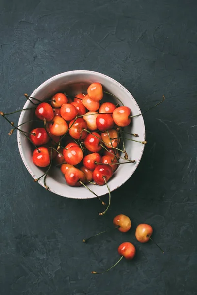 Vue de dessus des cerises douces fraîches mûres dans un bol sur noir — Photo de stock