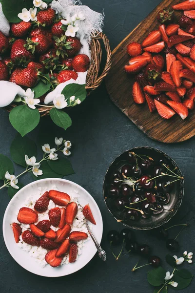 Top view of cottage cheese, jasmine flowers and fresh ripe summer berries on black — Stock Photo