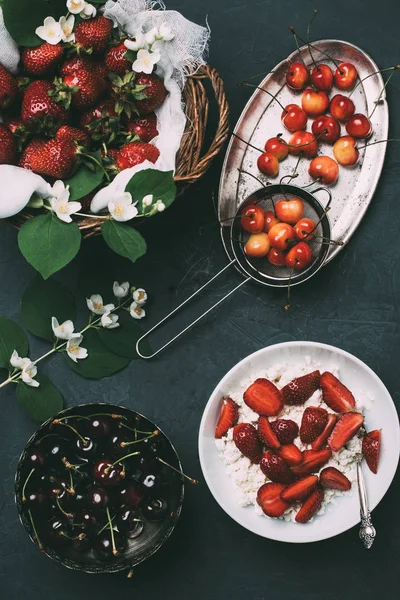 Vue du dessus du fromage cottage et des baies fraîches mûres d'été sur le noir — Photo de stock