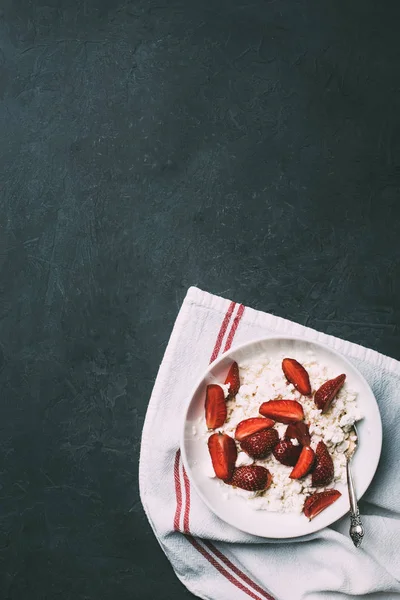 Blick von oben auf gesunden Quark mit reifen Erdbeeren auf schwarz — Stockfoto