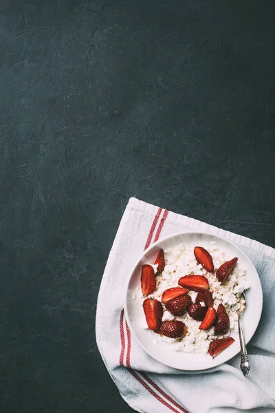 Top view of healthy cottage cheese with ripe strawberries on black — Stock Photo