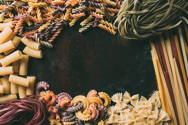 Vista dall'alto di vari tipi di pasta su tavolo in metallo rustico — Foto stock