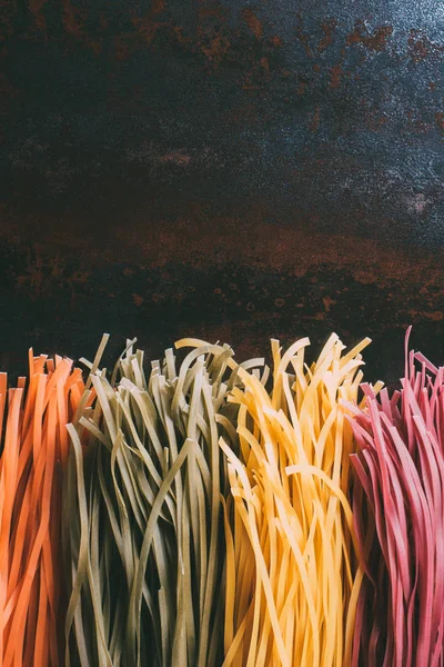 Erhöhte Ansicht der arrangierten bunten Tagliatelle Pasta in Reihe auf Metalltisch platziert — Stockfoto