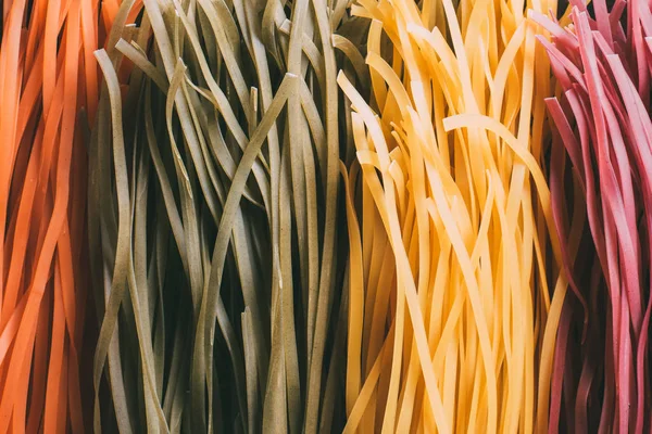 Vollbild von arrangierten bunten rohen Tagliatelle Pasta — Stockfoto