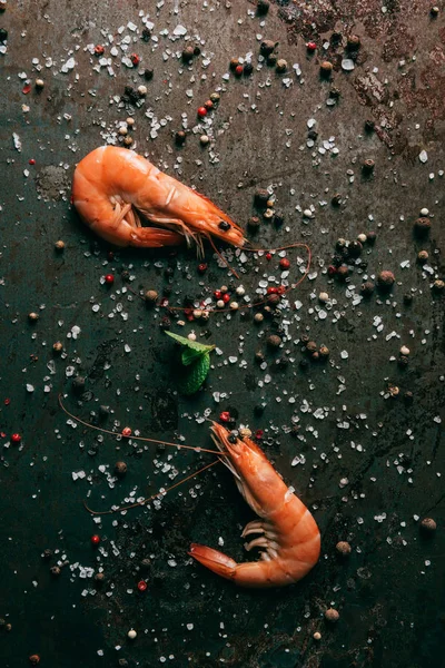 Top view of shrimps with mint on table with salt and black pepper — Stock Photo