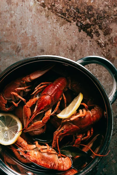 Elevated view of pile of crayfishes with lemon slices and bay leaf in saucepan — Stock Photo