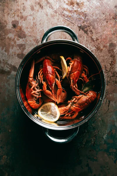 Vue du dessus des écrevisses avec feuilles de laurier et tranches de citron dans une casserole — Photo de stock