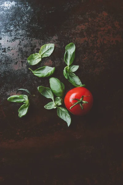 Vue du dessus de la tomate mûre rouge avec des feuilles de basilic — Photo de stock