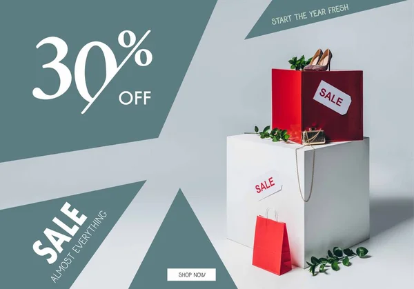 Twigs with green leaves, high heels and sale signs, summer sale concept — Stock Photo
