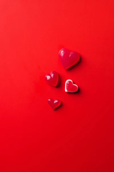 Vista dall'alto di caramelle a forma di cuore sulla superficie rossa — Foto stock