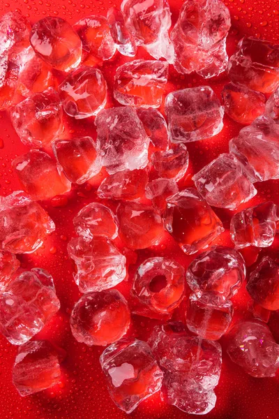 Vista dall'alto dei cubetti di ghiaccio sulla superficie rossa — Foto stock