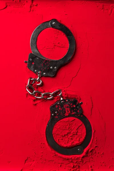 Von oben auf schwarze Handschellen rotes Pulver — Stockfoto