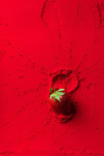 Vista superior de fresa roja sobre polvo rojo - foto de stock