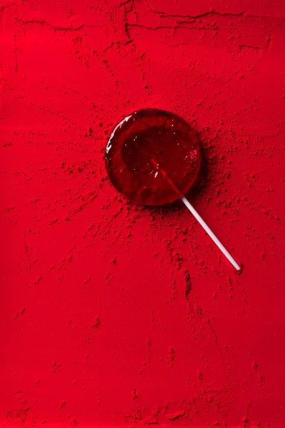 Vue du dessus de sucette rouge sur poudre rouge — Photo de stock