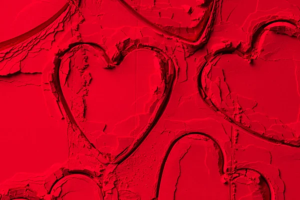 Vista elevada de las formas de los cortadores de galletas en forma de corazones en polvo rojo - foto de stock