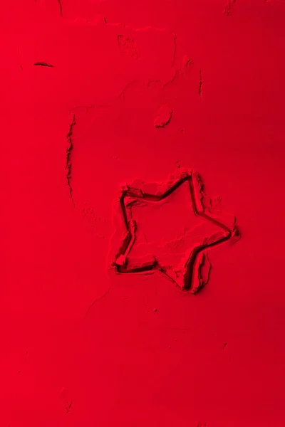 Vista elevada de la forma del cortador de galletas en forma de estrella sobre polvo rojo - foto de stock