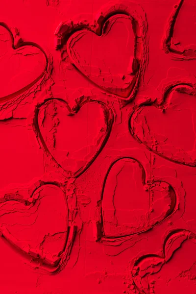 Top view of shapes of cookie cutters in shape of hearts on red powder — Stock Photo