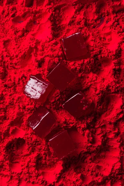 Vue du dessus de bonbons éparpillés sur poudre rouge — Photo de stock