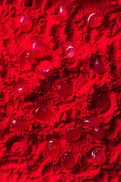 Top view of candies on red powder — Stock Photo