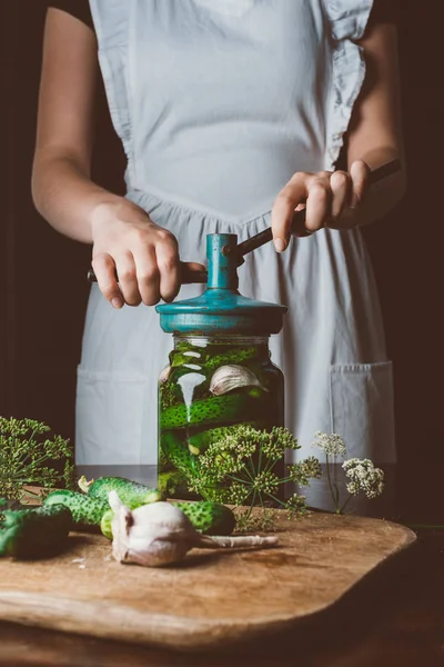 Imagem cortada de mulher preparando pepinos preservados na mesa da cozinha — Fotografia de Stock