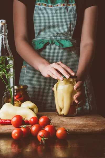 Imagem cortada de mulher preparando pimentas preservadas na cozinha — Fotografia de Stock