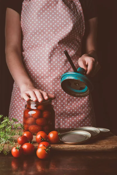 Cropped image of woman preparing preserved tomatoes at kitchen — Stock Photo