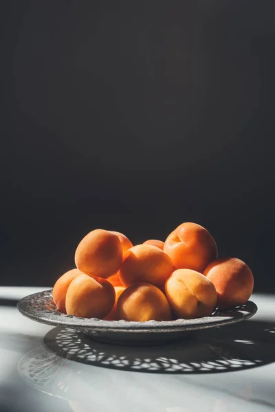 Food composition with ripe apricots in metal bowl with black background — Stock Photo