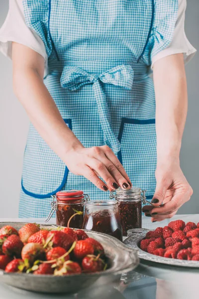 Partial view of woman doing jam from strawberries and raspberries at kitchen — Stock Photo